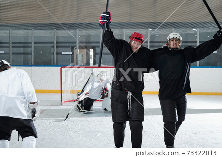 Excited hockey players in sports uniform expressing joy after successful play Excited hockey players in sports uniform expressing joy after successful play 73322013