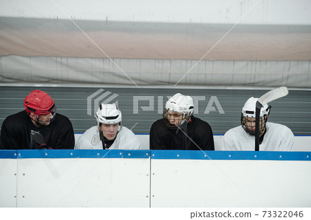 Group of young hockey players and their trainer in uniform preparing for play 73322046