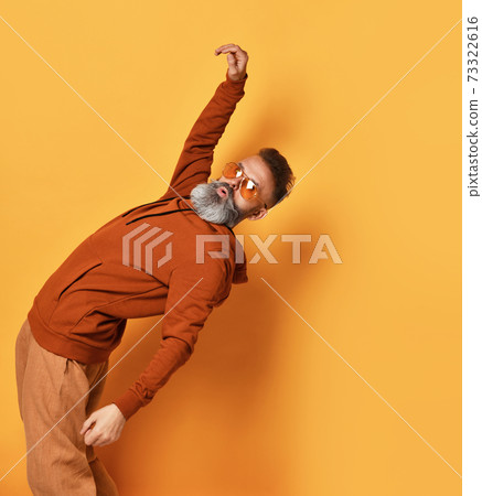 Strong bearded man bending backwards studio shot Strong bearded man bending backwards studio shot 73322616