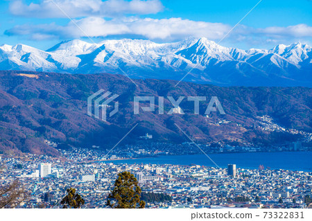 Snow-capped Yatsugatake mountain range and Lake Suwa [Nagano Prefecture] 73322831