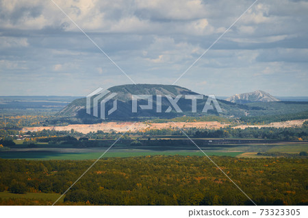 A top view of colourful forest trees and lake in the autumn season. 73323305