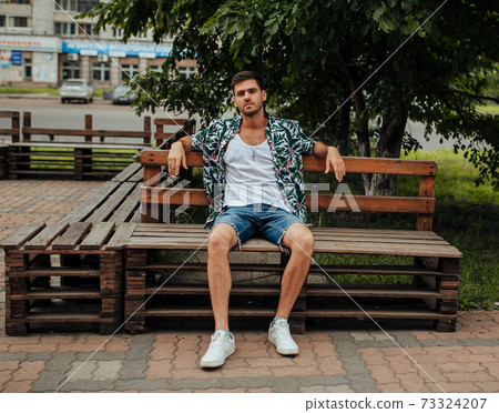 Adult guy in a Hawaiian shirt, walking down the street 73324207