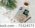 Glasses, tea and notebook placed on the table, dried flowers 73324573