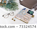 A notebook, a bag, glasses and dried flowers placed on the table 73324574