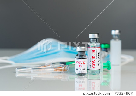 coronavirus covid-19 vaccine bottles and syringe injection and medical mask coronavirus covid-19 vaccine bottles and syringe injection and medical mask 73324907