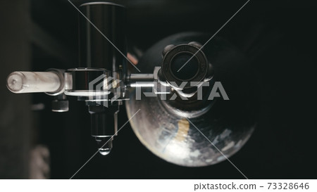 Forge workshop. Smithy manual production. A worker open gas cylinder vessel with oxygen for welding. Cinematic black look. Forge workshop. Smithy manual production. A worker open gas cylinder vessel with oxygen for welding. Cinematic black look. 73328646