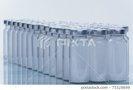 Glass medical ampoule vial for injection. Medicine is dry white drug penicillin powder or liquid with of aqueous solution in ampulla. Close up. 73328699