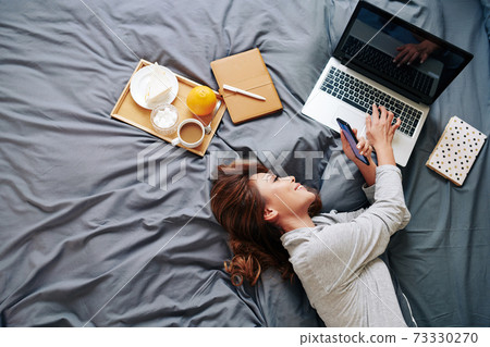 Woman resting on bed 73330270
