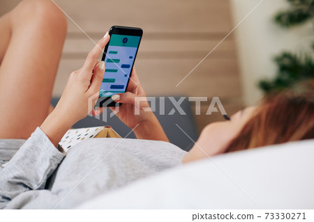 Young woman texting boyfriend Young woman texting boyfriend 73330271