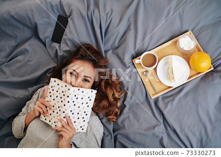 Attractive woman with interesting book 73330273