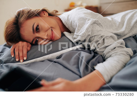 Woman resting in bed on Sunday morning Woman resting in bed on Sunday morning 73330280