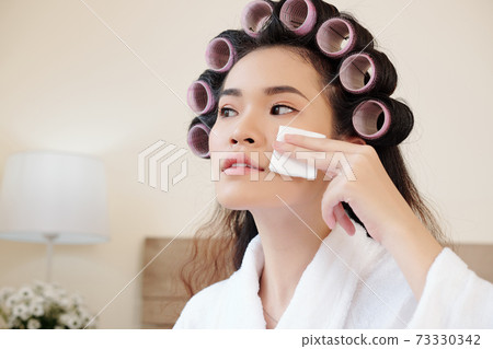 Woman applying skin toner 73330342