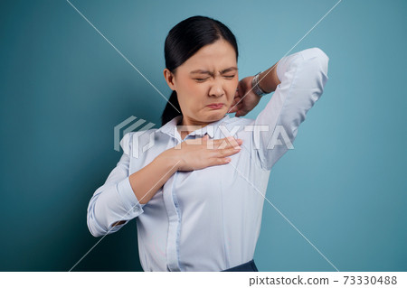 Asian woman testing smelling her armpit. Asian woman testing smelling her armpit. 73330488