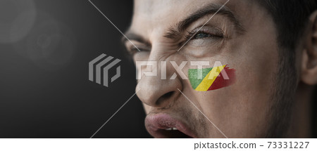 A screaming man with the image of the Congo national flag on his face A screaming man with the image of the Congo national flag on his face 73331227