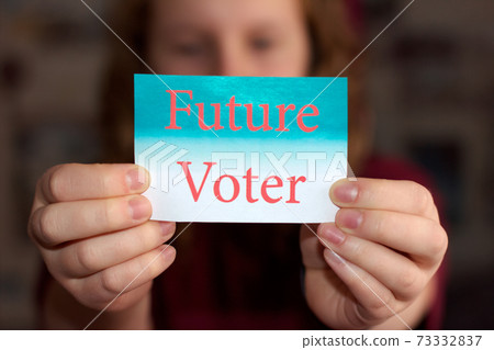 Future Voter sign in young woman's hands. Voting or making choice concept. Future Voter sign in young woman's hands. Voting or making choice concept. 73332837