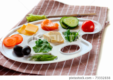 palette with colorful vegetables, fish and greens, creative food design, funny and healthy meal for kids.  73332838