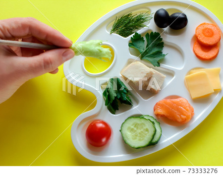 palette with colorful vegetables, fish and greens, creative food design, funny and healthy meal for kids.  73333276