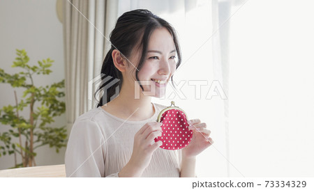 A young woman with a wallet 73334329
