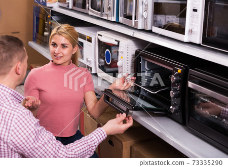 man choosing new modern mini oven 73335290