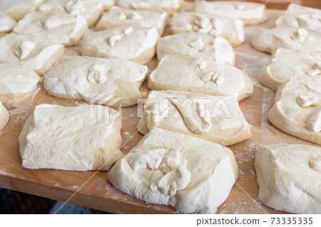 Prepared raw dough on tray in bakery Prepared raw dough on tray in bakery 73335335