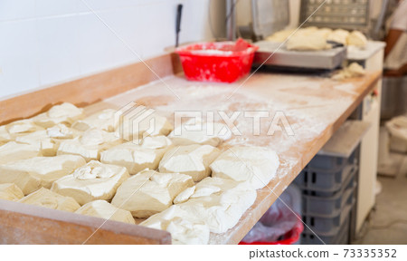 Prepared raw dough on tray in bakery Prepared raw dough on tray in bakery 73335352