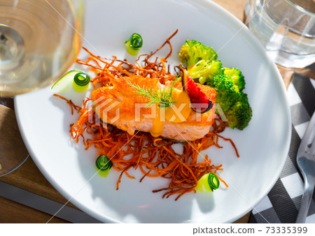 Fried salmon with smoked julienne carrot, broccoli, cucumber, figs 73335399
