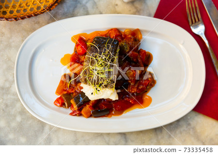 cuisine spanish candied fish with stewed vegetables served on white plate cuisine spanish candied fish with stewed vegetables served on white plate 73335458