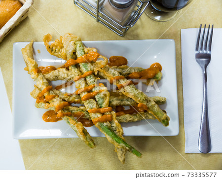 Asparagus fried in batter with romesco sauce 73335577