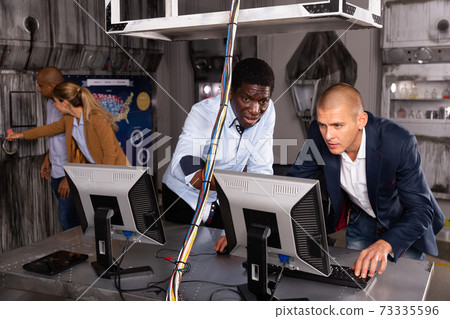 Men in panic looking for a solution on the computer in quest room Men in panic looking for a solution on the computer in quest room 73335596