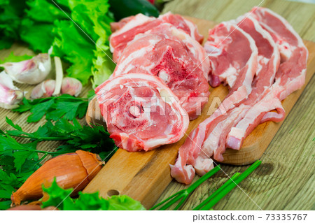 Fresh slices of mutton and vegetables assortment on natural wooden desk 73335767