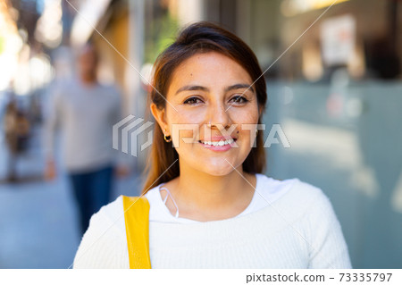 Portrait of beautiful latin woman on city street. 73335797