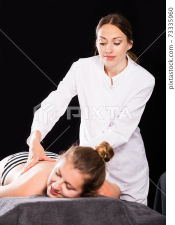 Professional massage therapist massaging woman Professional massage therapist massaging woman 73335960