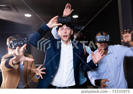 Friends playing video games using virtual reality glasses Friends playing video games using virtual reality glasses 73335975