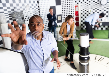 Portrait of man in quest room with other multiracial people Portrait of man in quest room with other multiracial people 73336178