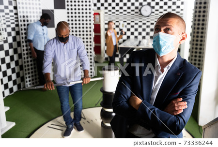 Friends with face mask playing in quest room 73336244