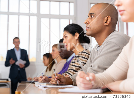 Adult latin american man listening to lecture in classroom Adult latin american man listening to lecture in classroom 73336345