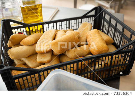 Fresh hot ciabatta in crate in bakery Fresh hot ciabatta in crate in bakery 73336364