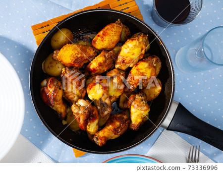 fried and served hot chicken wings in pan fried and served hot chicken wings in pan 73336996