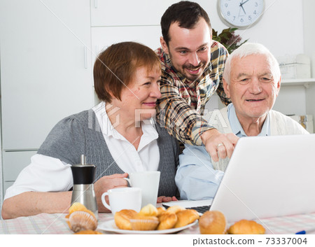 Parents and son watching photos Parents and son watching photos 73337004