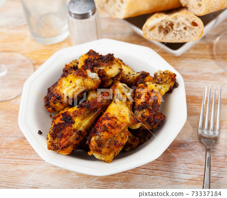 grill spicy buffalo wings on blue plate for lunch 73337184