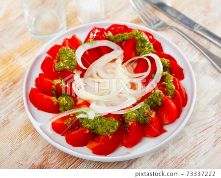Fresh tomatoes with green pesto sauce and onions Fresh tomatoes with green pesto sauce and onions 73337222