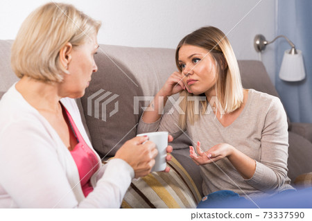 Mom and adult daughter talking 73337590