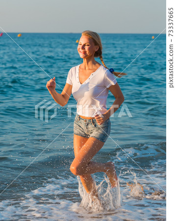 Sportswoman is jogging on the beach Sportswoman is jogging on the beach 73337665