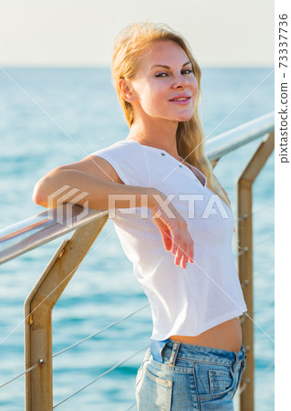 Elegant woman is posing on pirce in her free time Elegant woman is posing on pirce in her free time 73337736