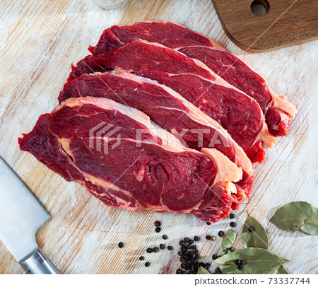 Raw beef steaks with bay leaves and black pepper Raw beef steaks with bay leaves and black pepper 73337744