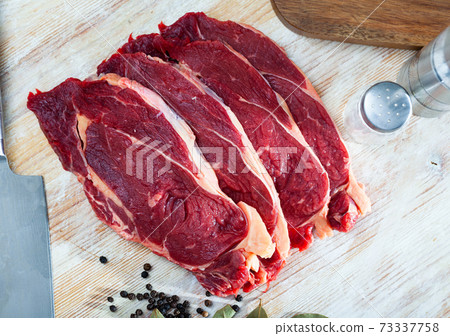 Raw beef steaks with bay leaves and black pepper Raw beef steaks with bay leaves and black pepper 73337758