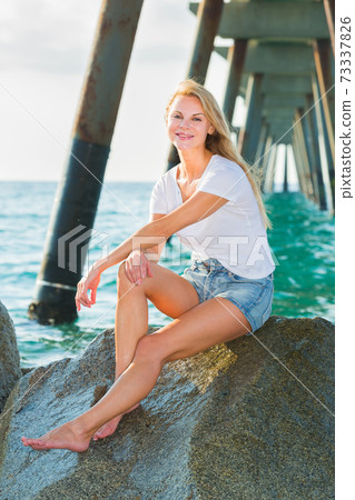 Female is posing on the rocks in her free time 73337826