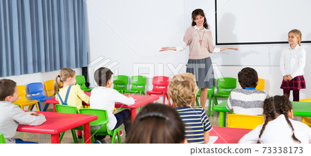 Teacher near whiteboard with schoolgirl 73338173