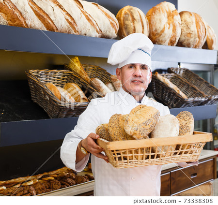 bakery male worker with tasty and fresh bread products on counter bakery male worker with tasty and fresh bread products on counter 73338308