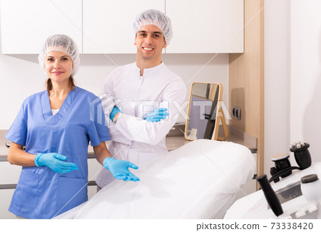 Two cosmetologists welcoming to clinic Two cosmetologists welcoming to clinic 73338420